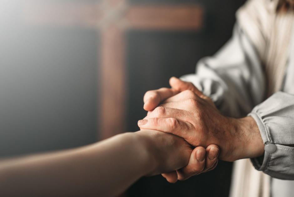 An older adult holding the hand of a younger adult